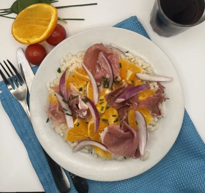 Salade de riz aux saveurs méditerranéennes : orange, jambon italien et oignons rouges