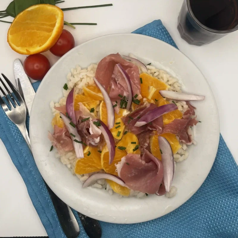 Salade de riz aux saveurs méditerranéennes : orange, jambon italien et oignons rouges